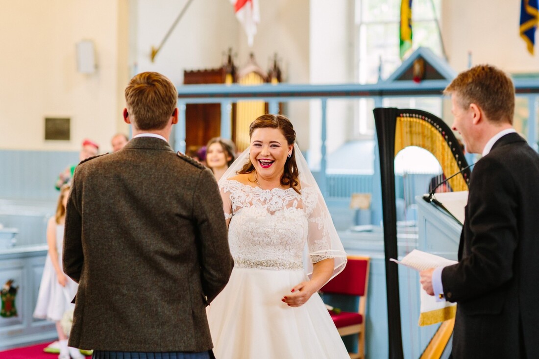 smiling bride at wedding ceremony at canongate kirk